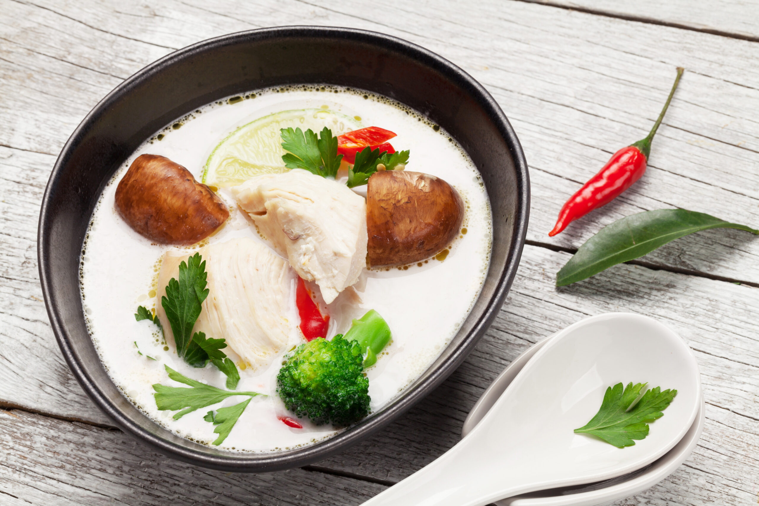 Tom Kha traditional Thai soup with chicken, mushrooms, coconut milk and hot spices