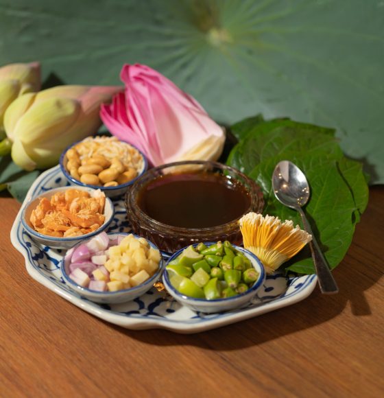 A set of Miang kham, Thai appetizer food with Lotus flower and leaf wrapped on traditional ceramic serving dish.